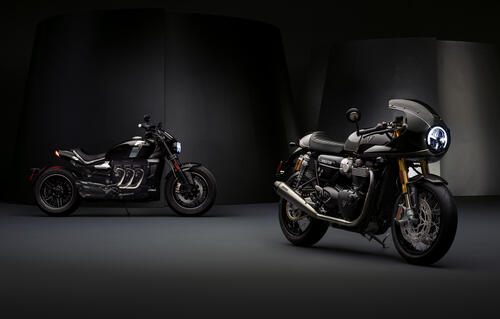 Two black motorcycles in a dark garage