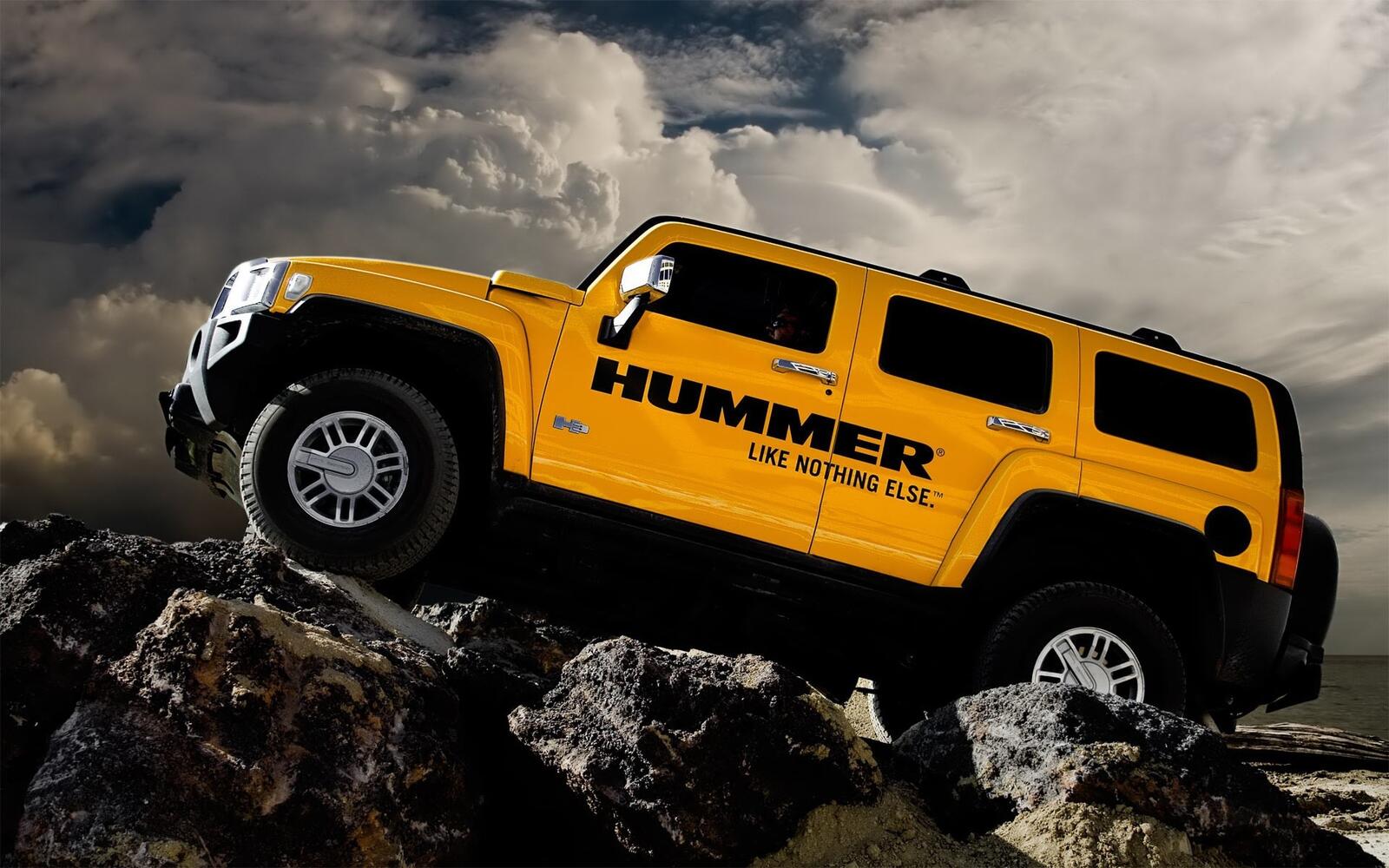 Free photo Yellow Hummer H3 going over the rocks.