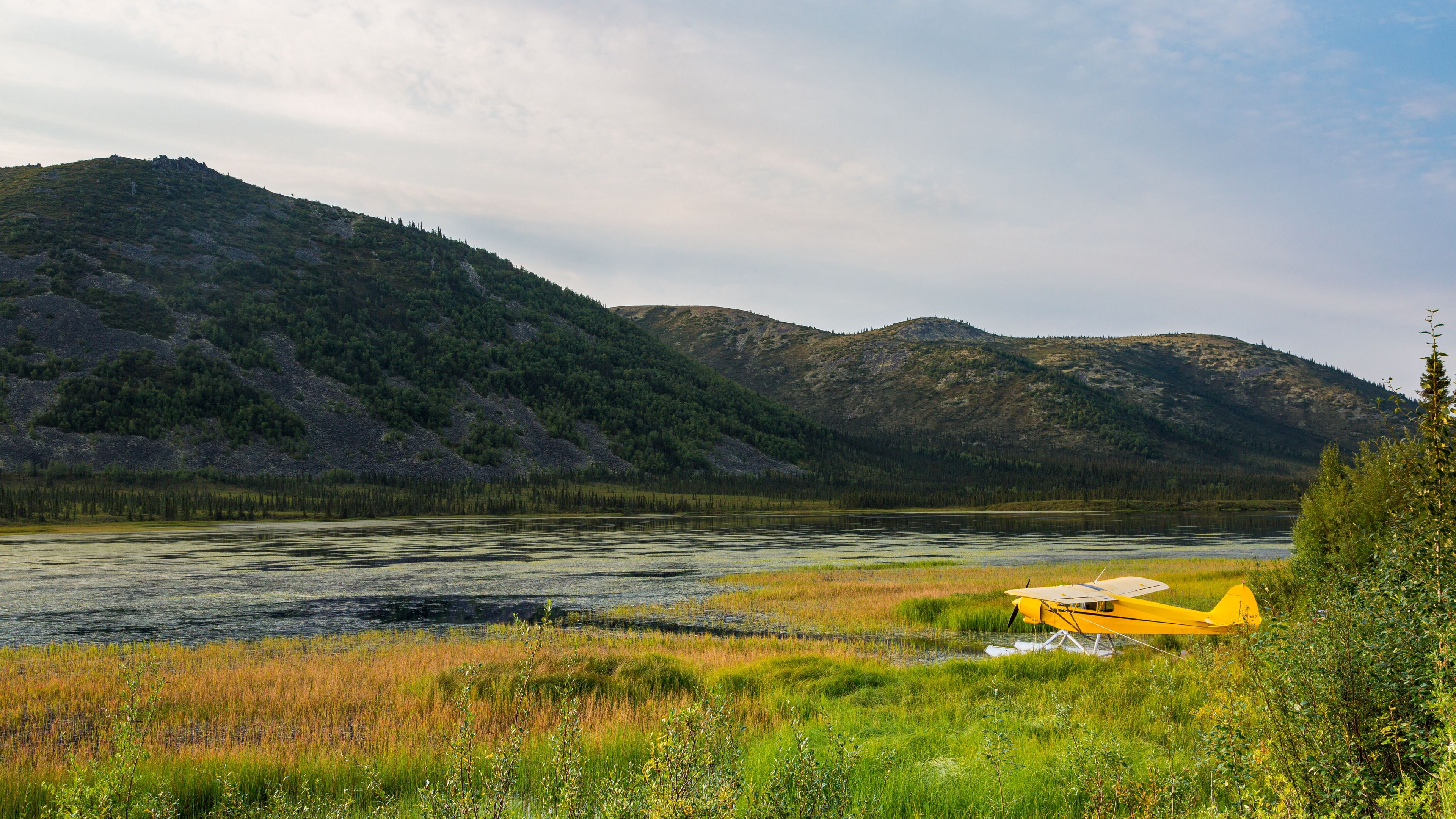 Бесплатное фото Желтый самолет припаркован на берегу реки