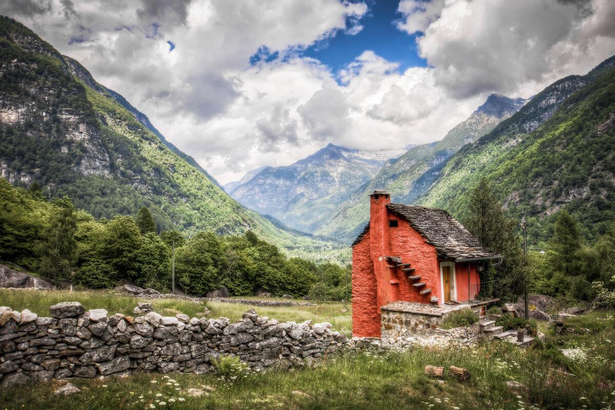 Picture of an old red brick cabin in the mountains.