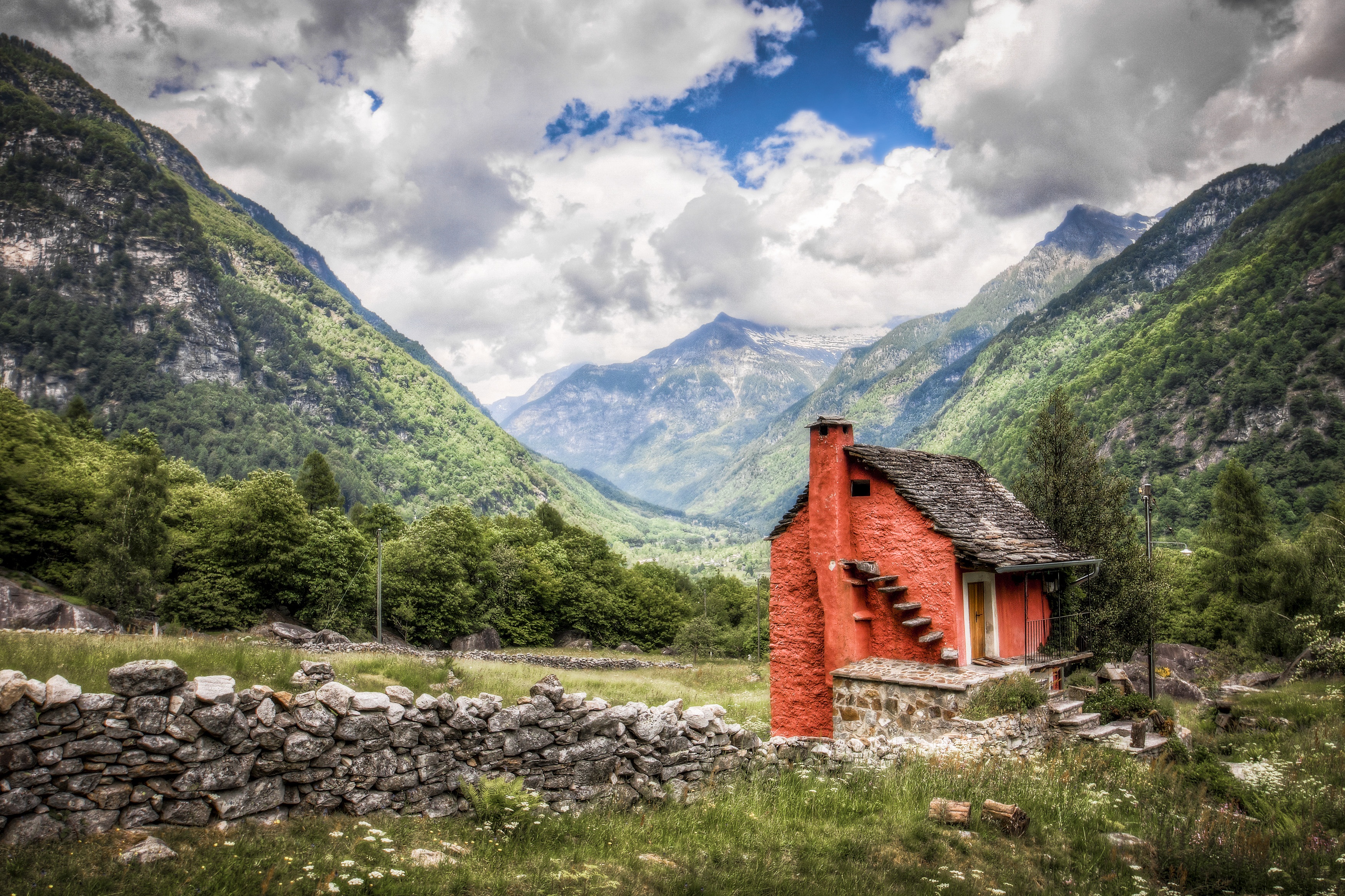 Free photo Picture of an old red brick cabin in the mountains.