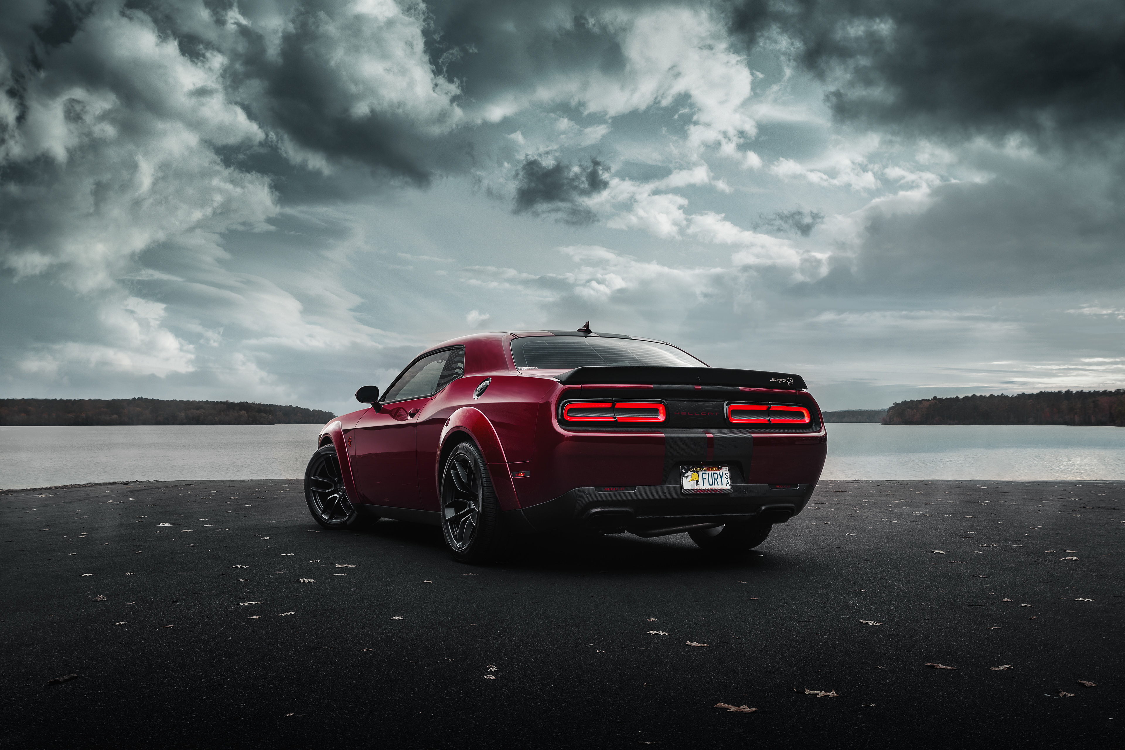 Free photo Red 2019 Dodge Challenger Srt Hellcat Widebody on the riverbank photographed from behind