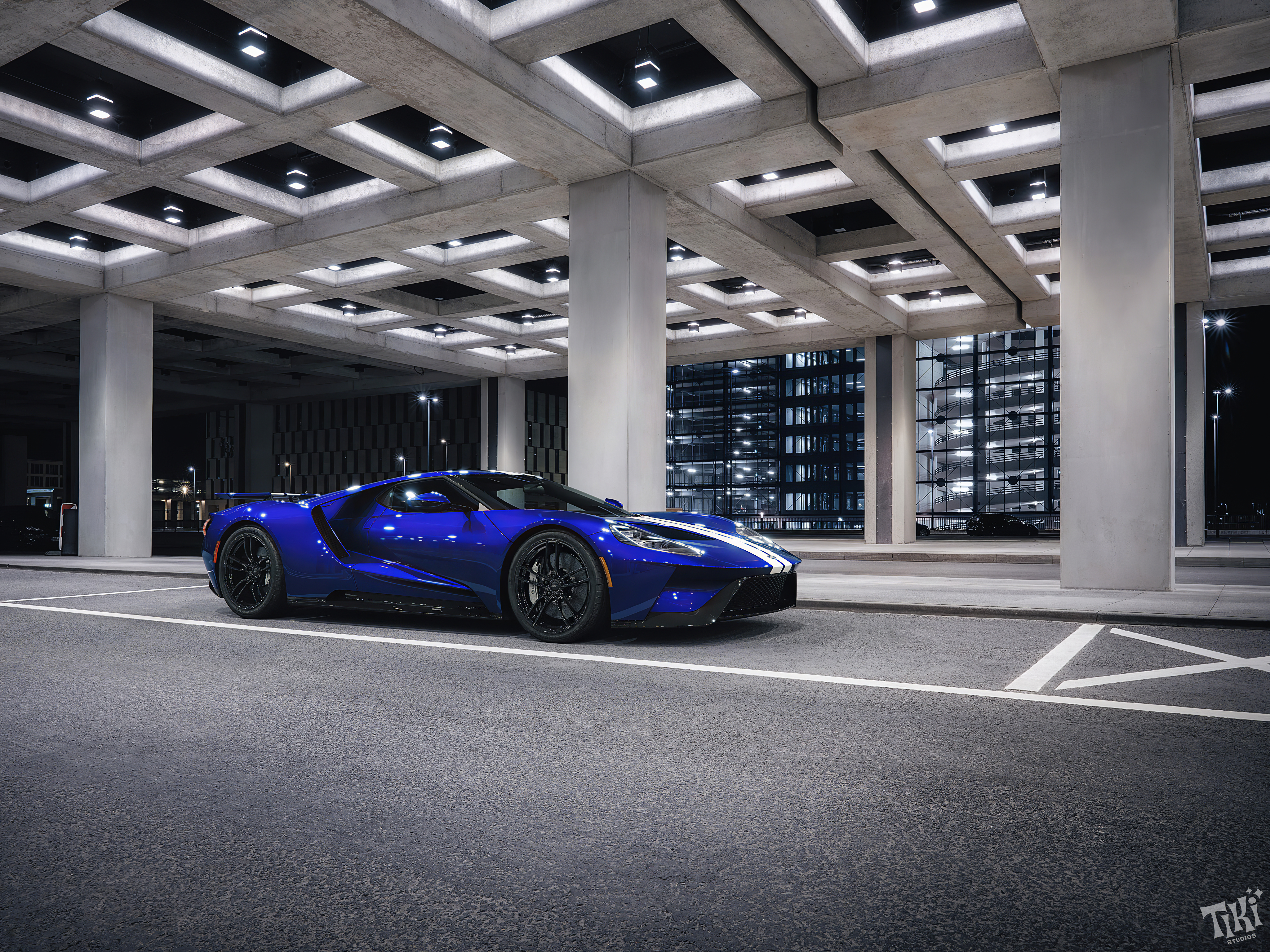 Free photo Blue Ford Gt40 with white stripes at night in bright light