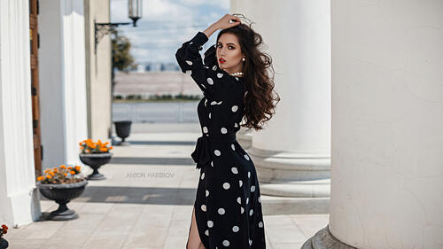 Dark-haired girl in a black dress with white polka dots