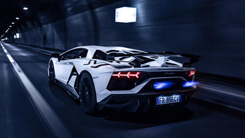 White Lamborghini Aventador with fire from the exhaust pipes