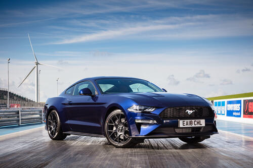 Темно-синий Ford Mustang на драговой дороге