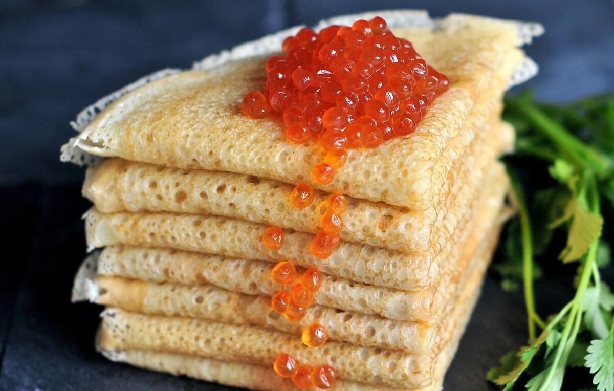 Wallpaper with delicate pancakes with red caviar