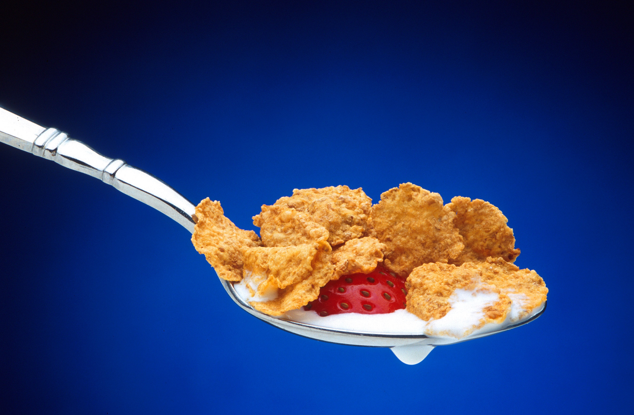 Free photo Spoon in cereal and strawberries in yogurt