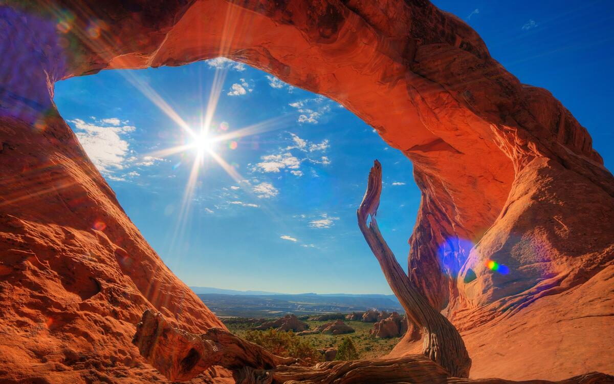 An arch in a desert canyon on a sunny afternoon.