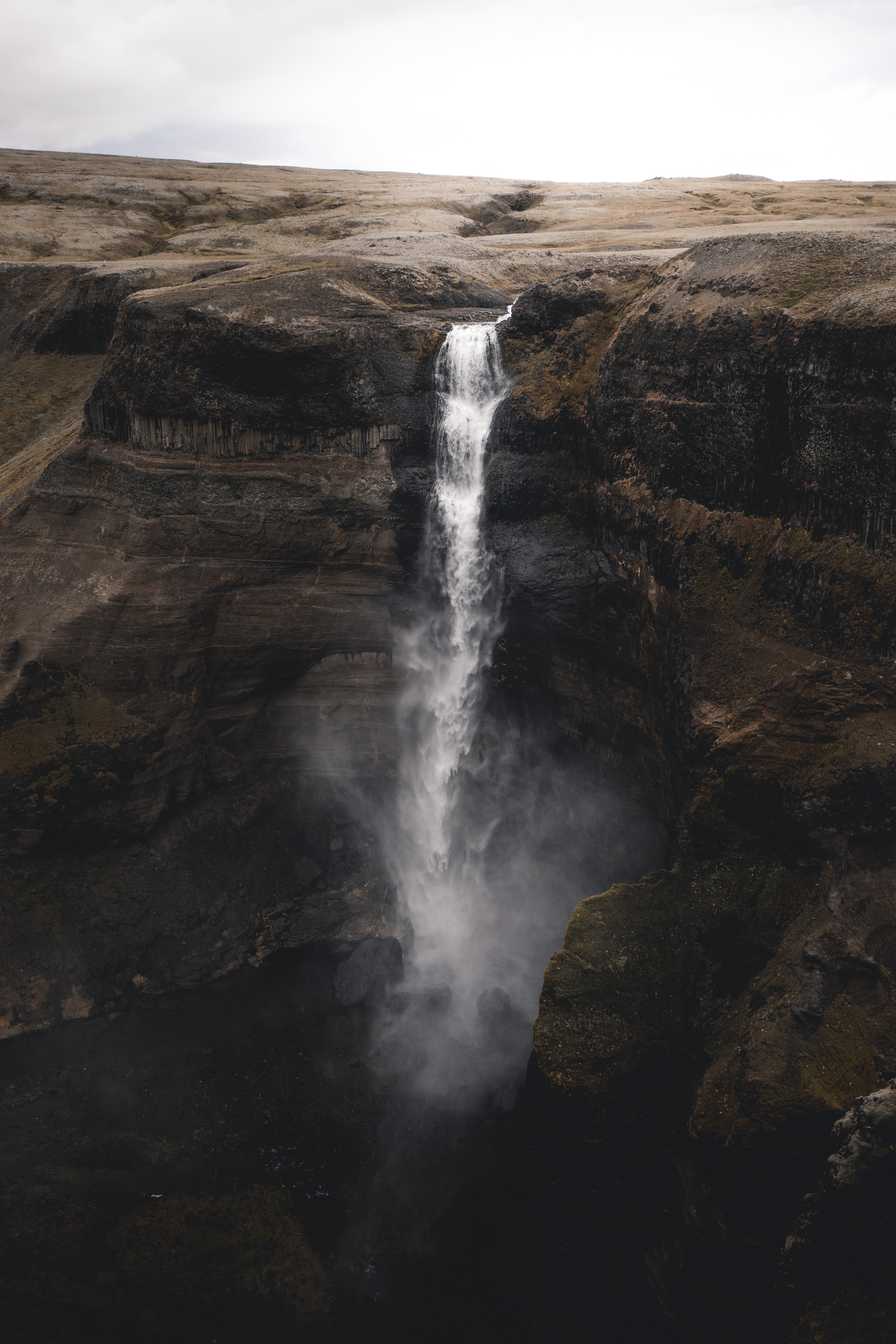 免费照片一条沿着悬崖的河流，峡谷中的瀑布。