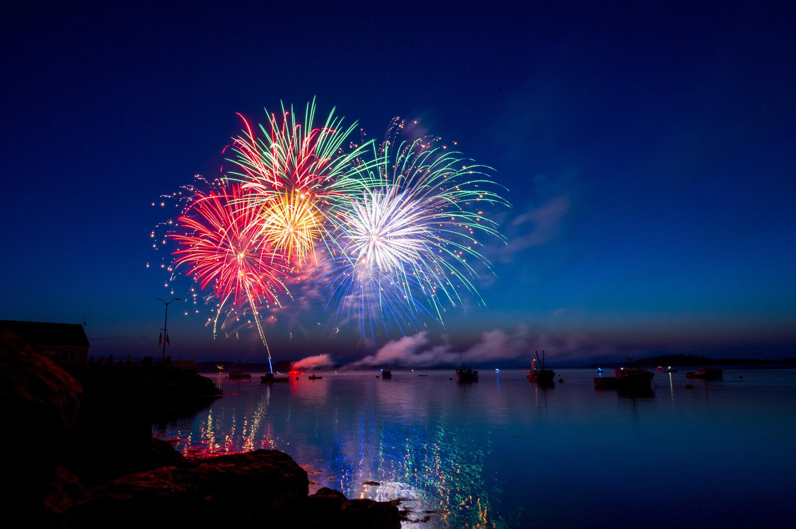 Бесплатное фото Ночной фейерверк над рекой с кораблями