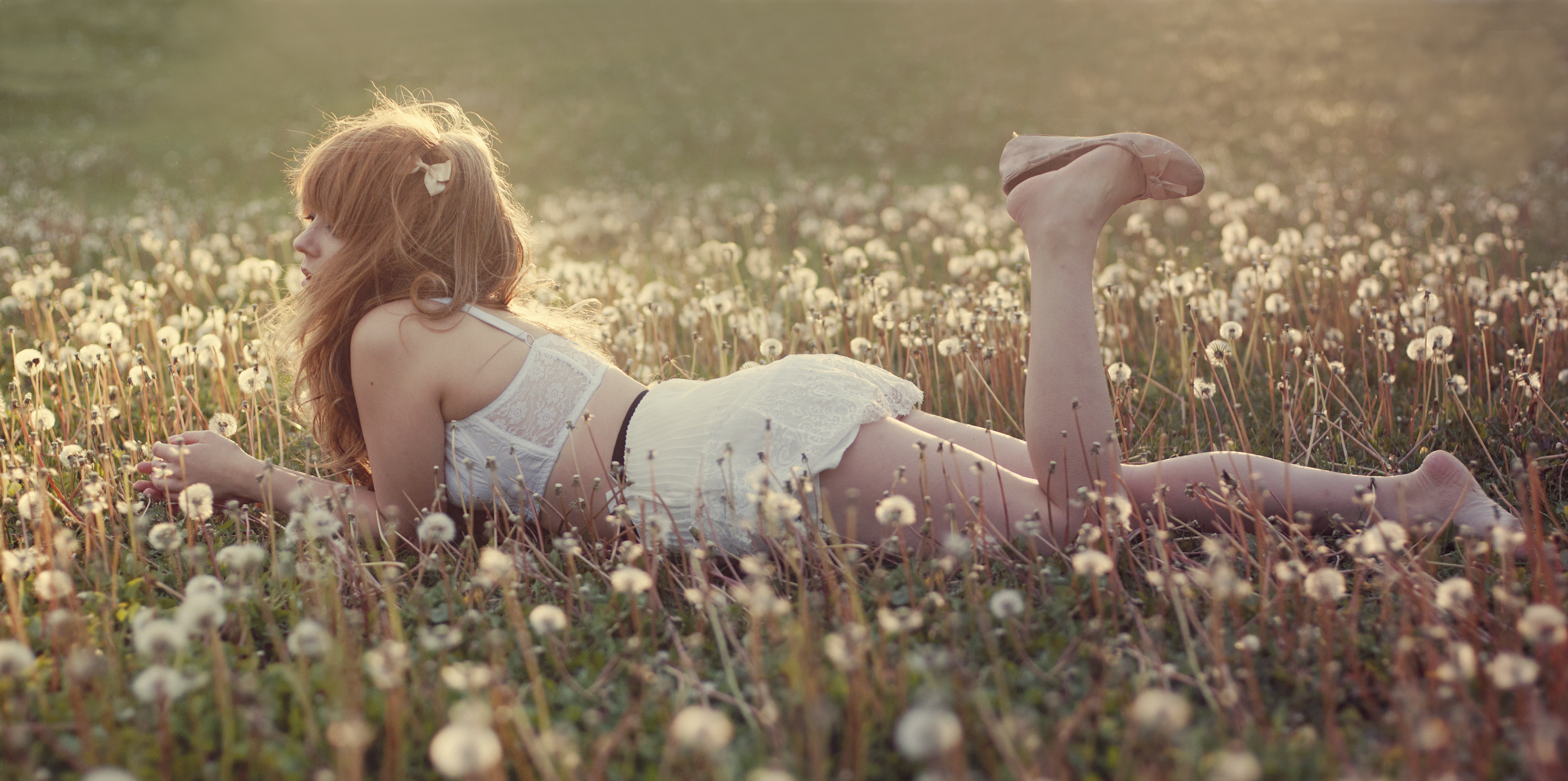 Бесплатное фото Девушка на поле с одуванчиками