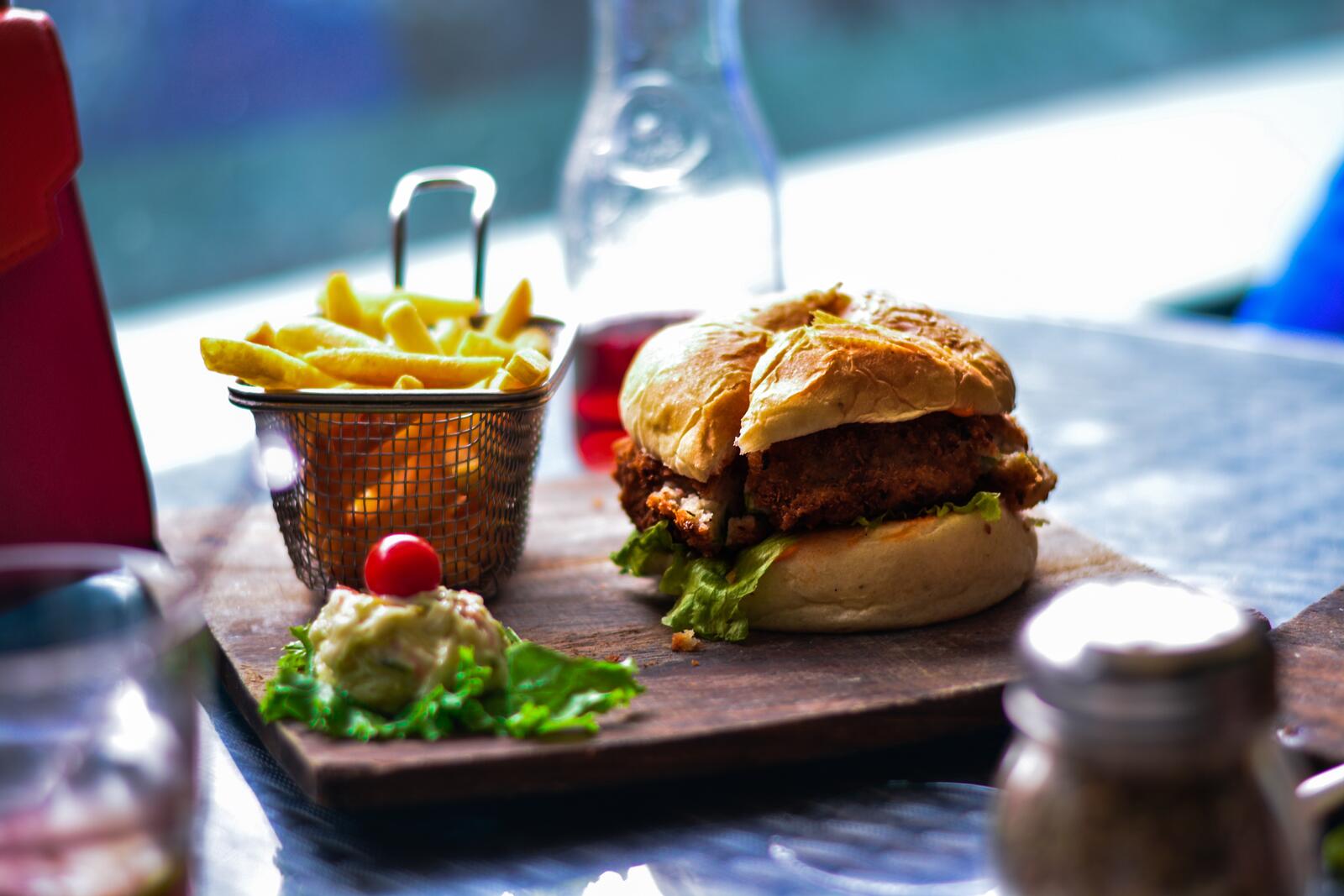 Бесплатное фото Гамбургер с картошкой фри на разделочной доске