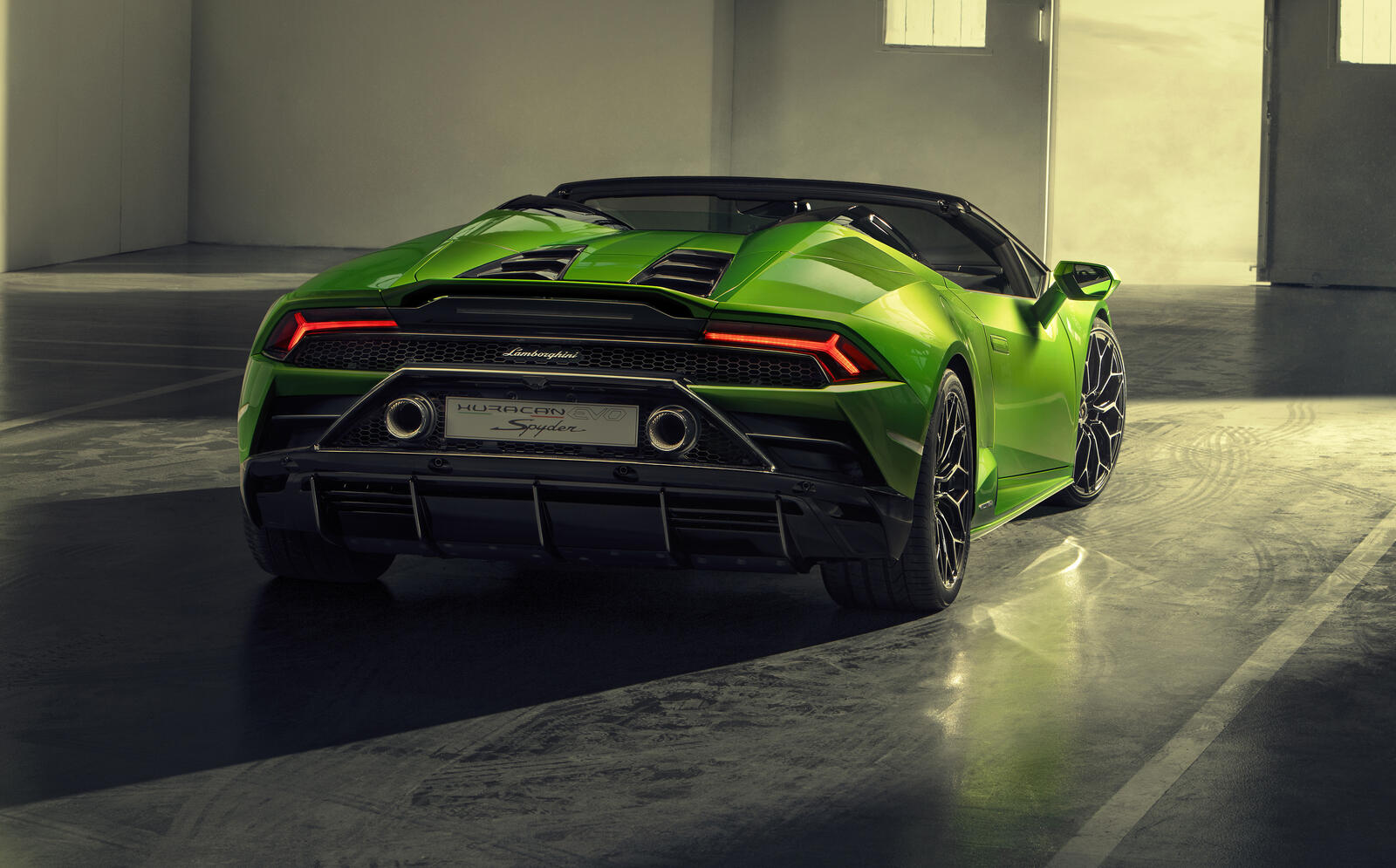 Free photo Lamborghini Huracan Evo Spyder in light green convertible body photographed from behind