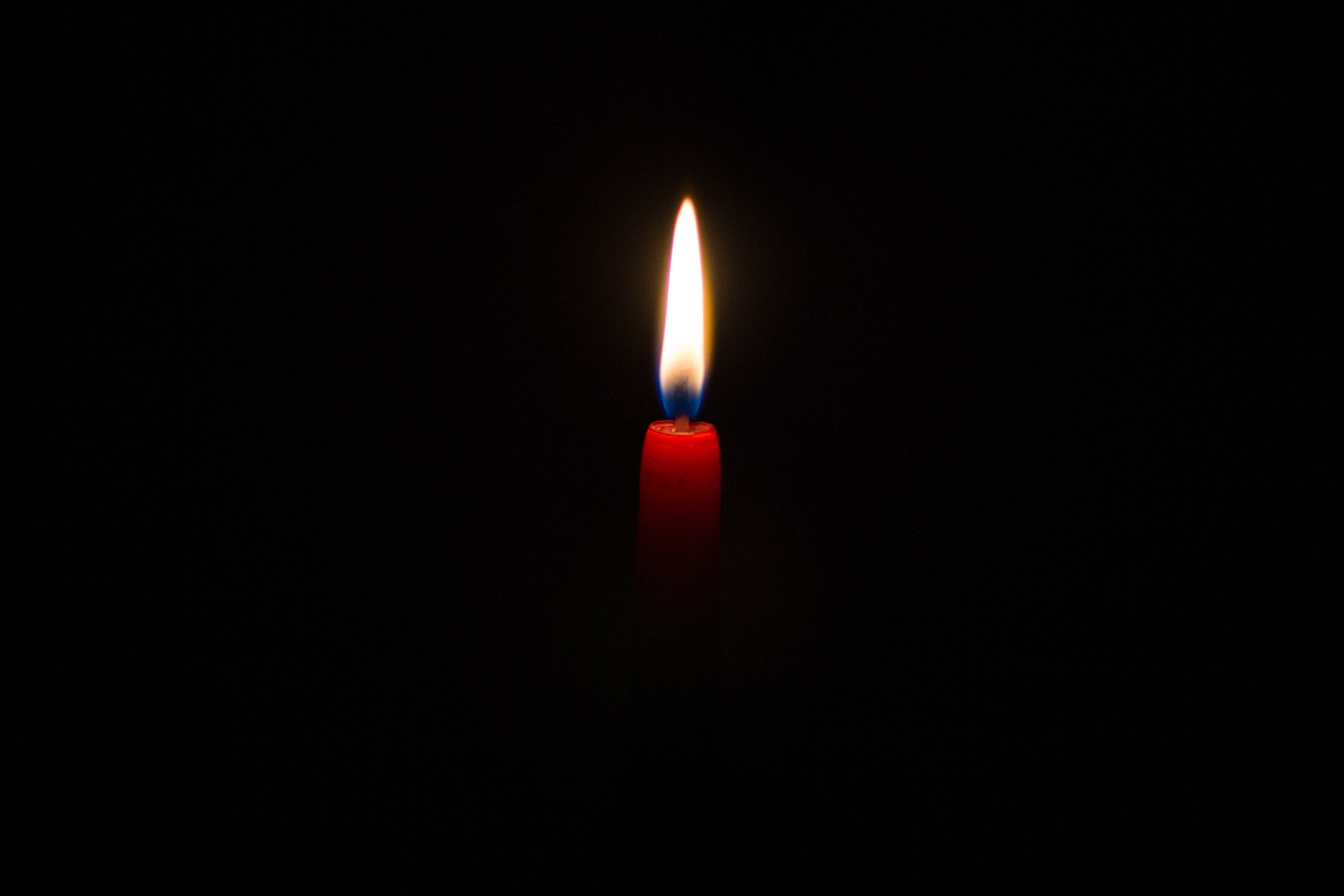黑色背景上燃烧的红蜡烛