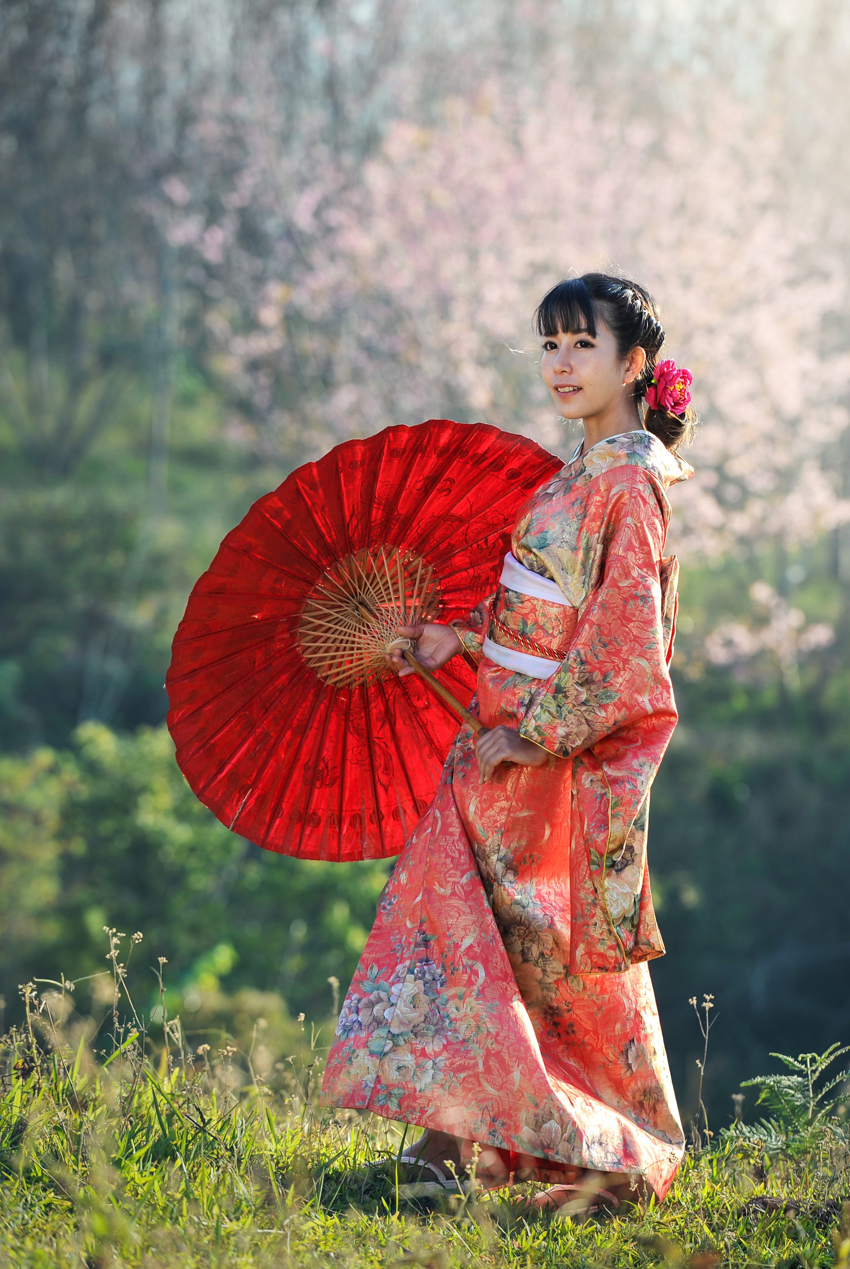 A girl in a kimono with a red umbrella.