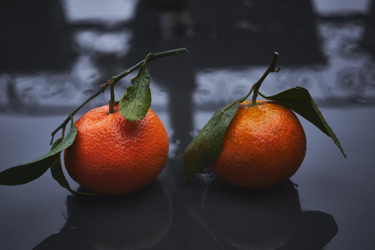 Два оранжевых мандарина с зелёными листиками