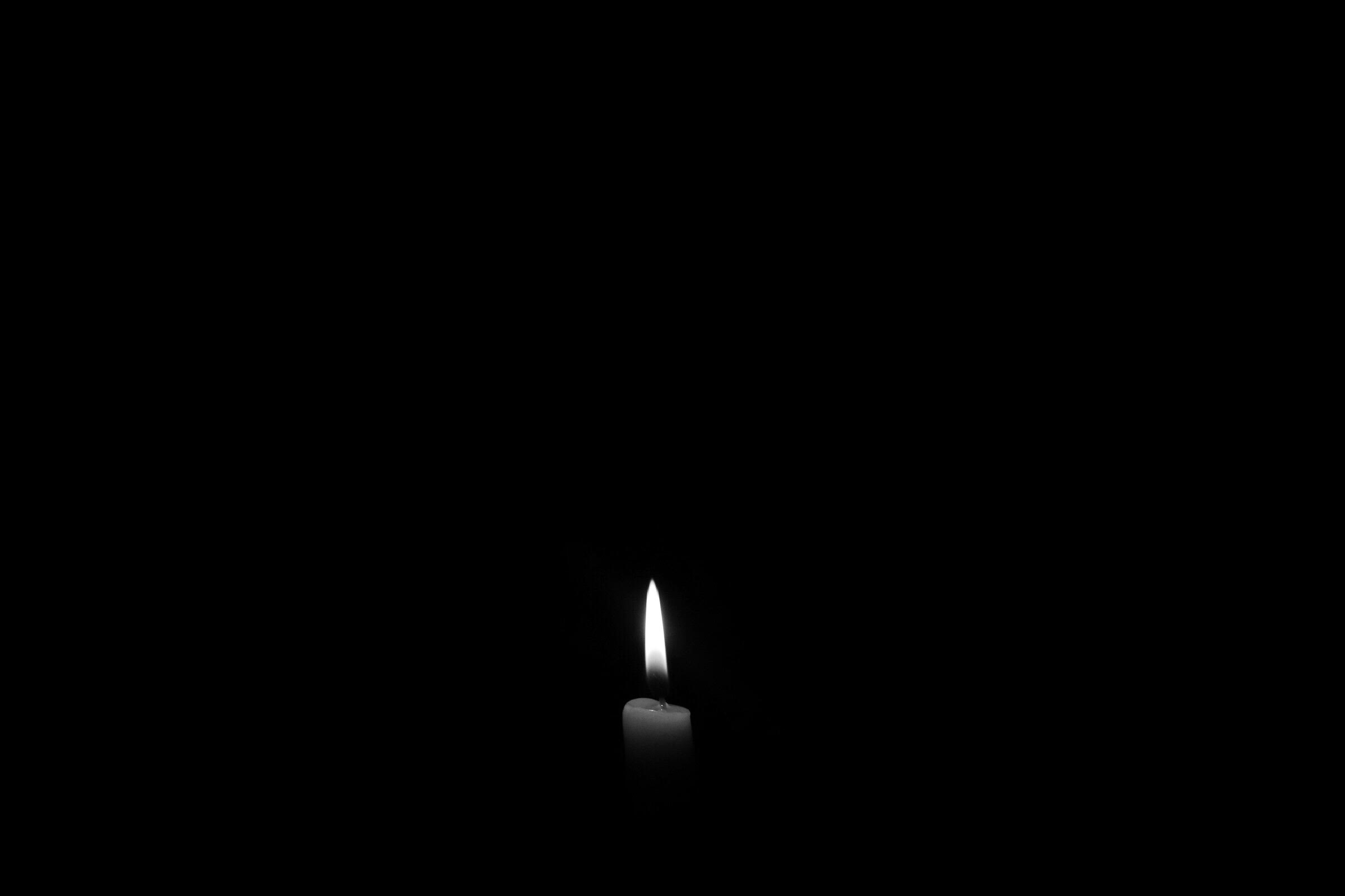 A lonely candle in the darkness