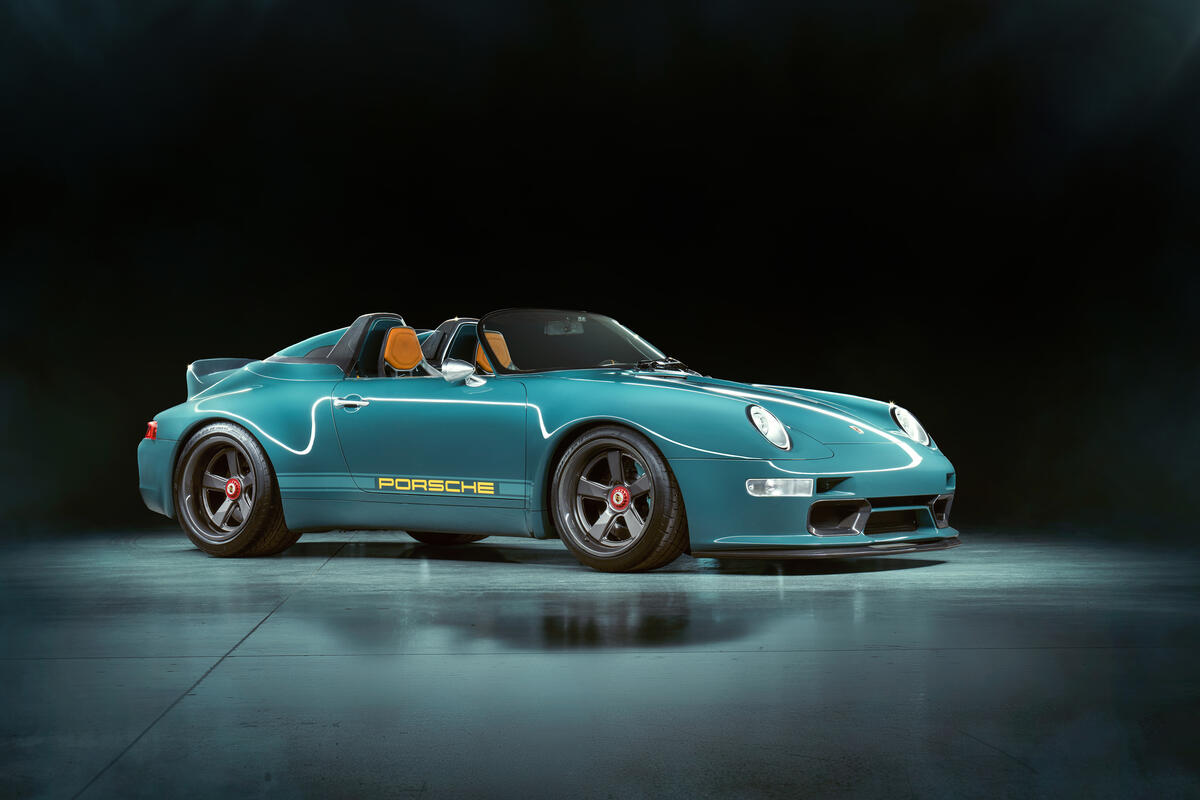 Голубой Porsche 911 2021 года на темном фоне
