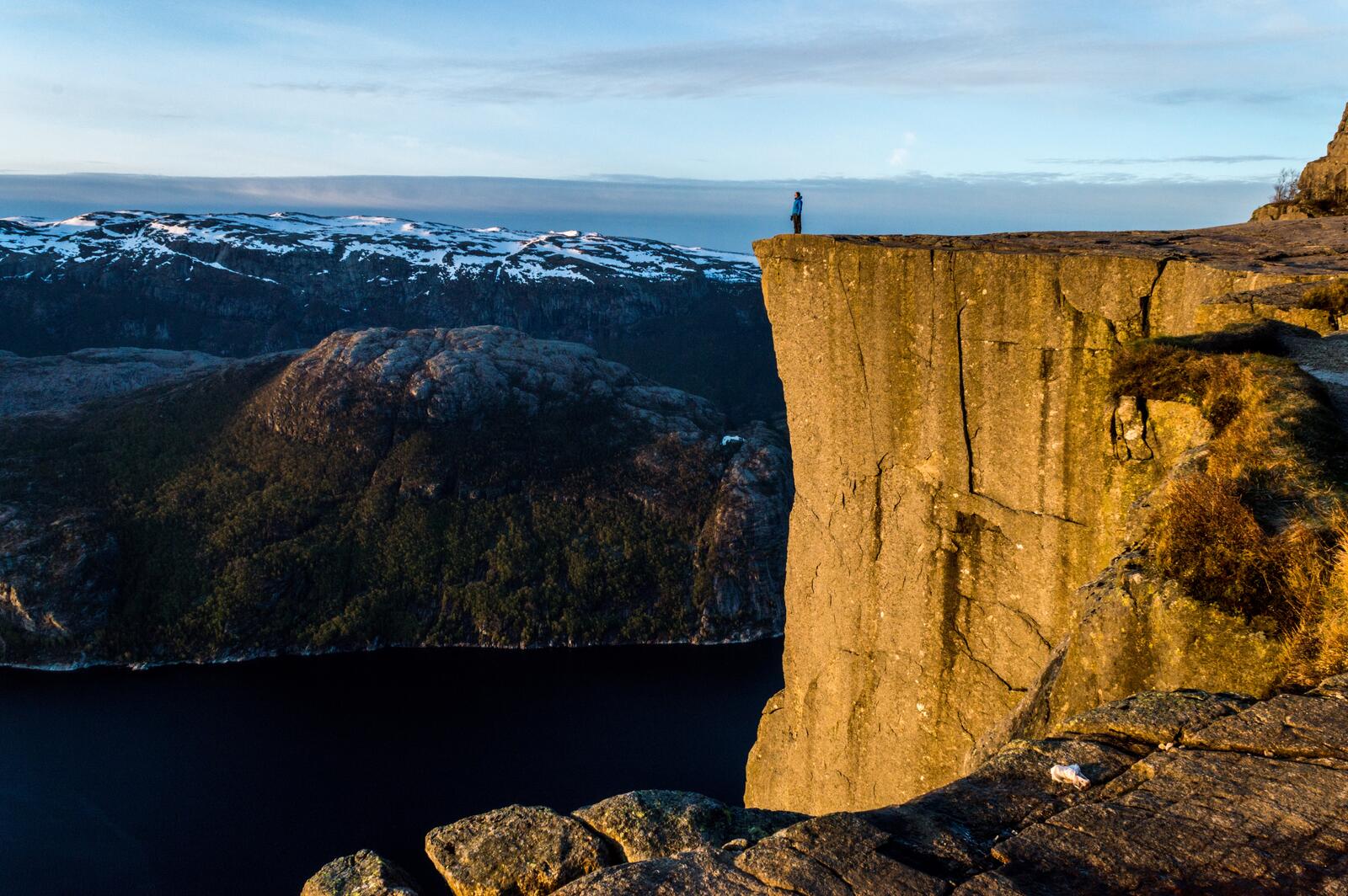 Free photo A man stands on the cliff of a large rock