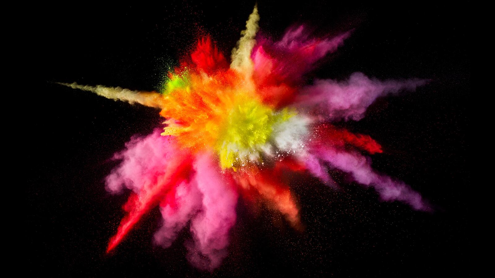Free photo Exploding colored powder on a black background