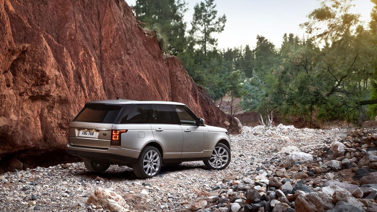 Серебристый Range Rover едет по каменной дороге