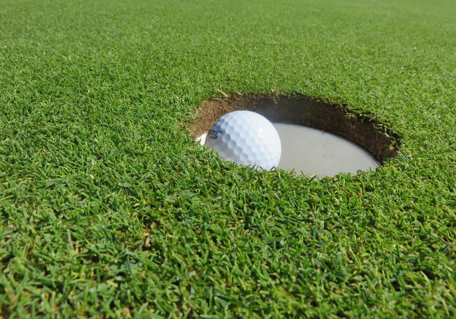 Бесплатное фото Мяч для гольфа падает в лунку