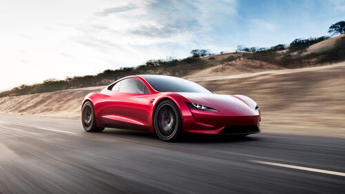 Red Tesla roadster goes down the road at high speed
