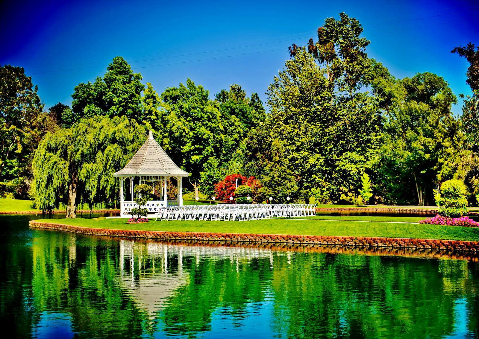 Free photo Summer gazebo by the water with a lawn and dense forest