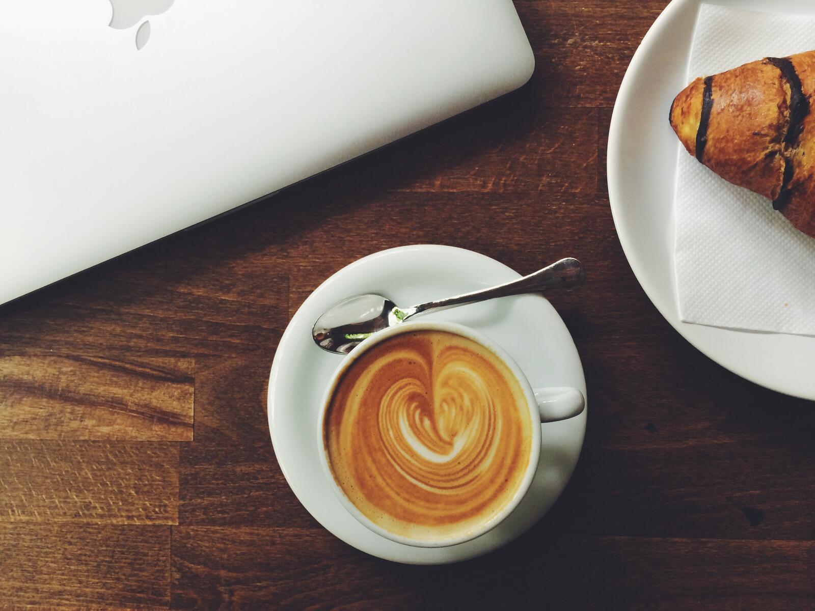 Бесплатное фото Утренняя чашка с латте на деревянном столе