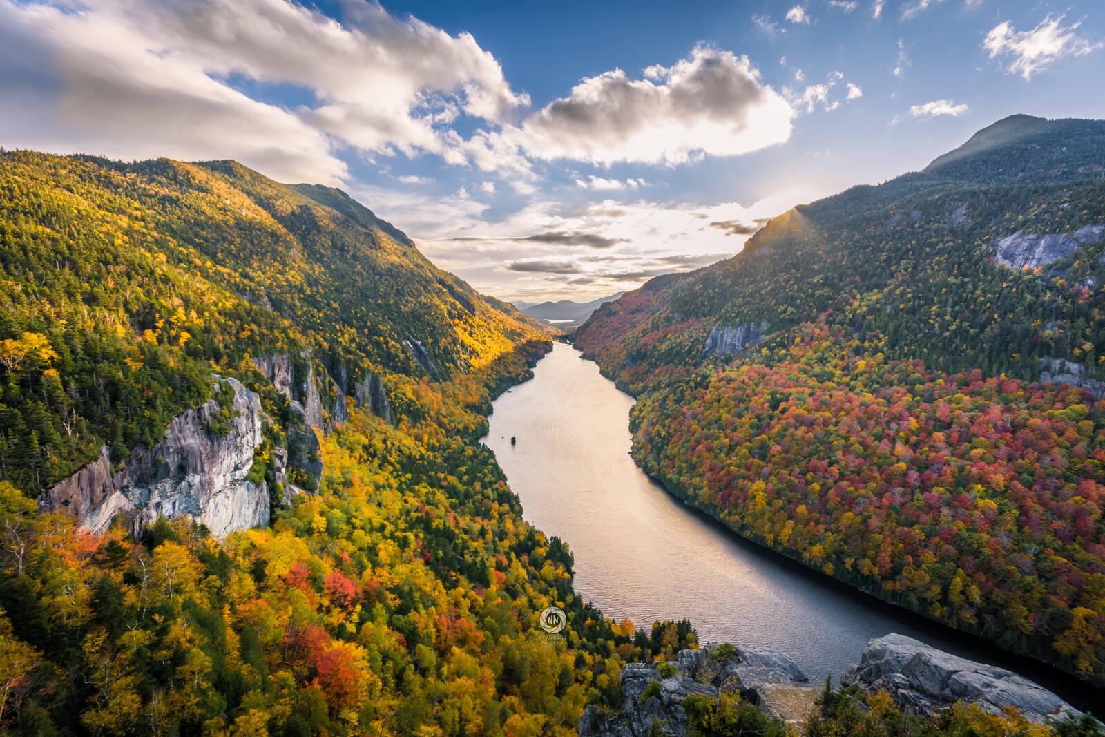 Бесплатное фото Река протекающая у подножья гор с осенними деревьями