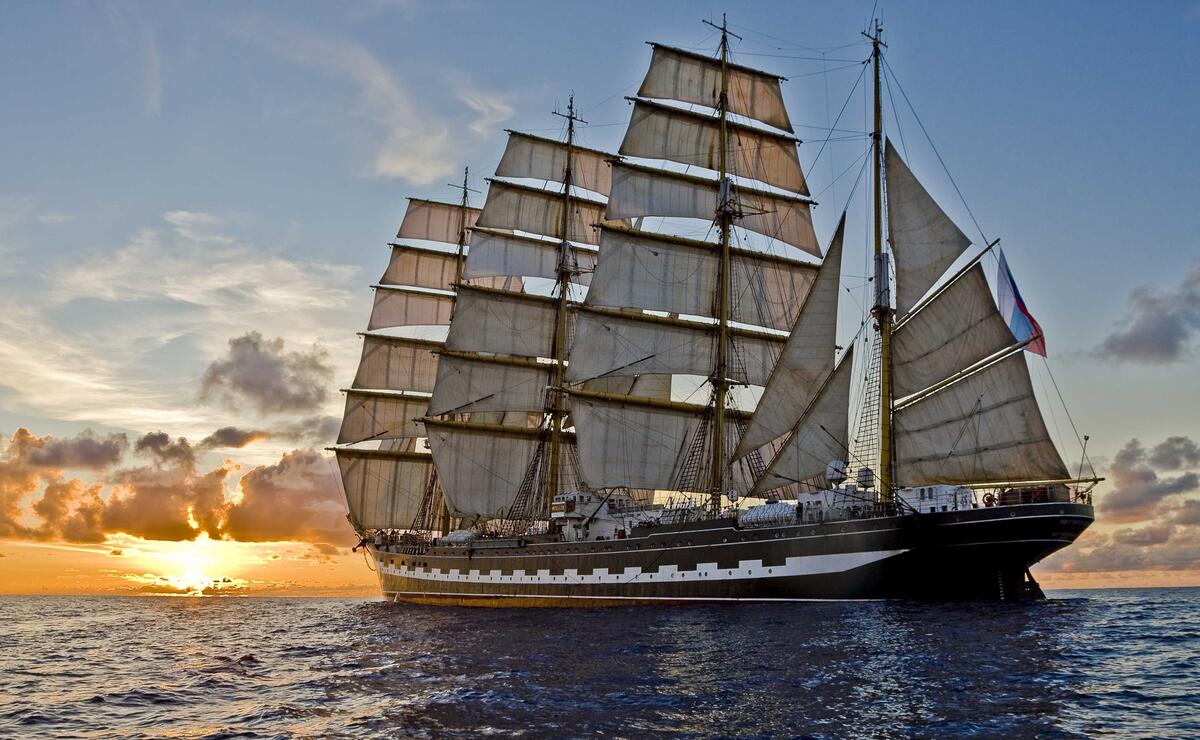 A large sailing ship sails the sea at sunset in the afternoon