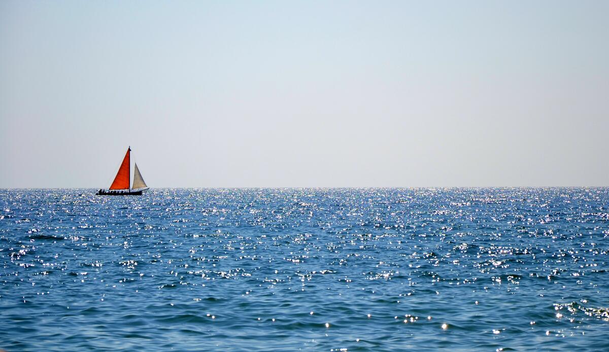 A lonely sailboat sails the sea