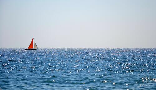 A lonely sailboat sails the sea