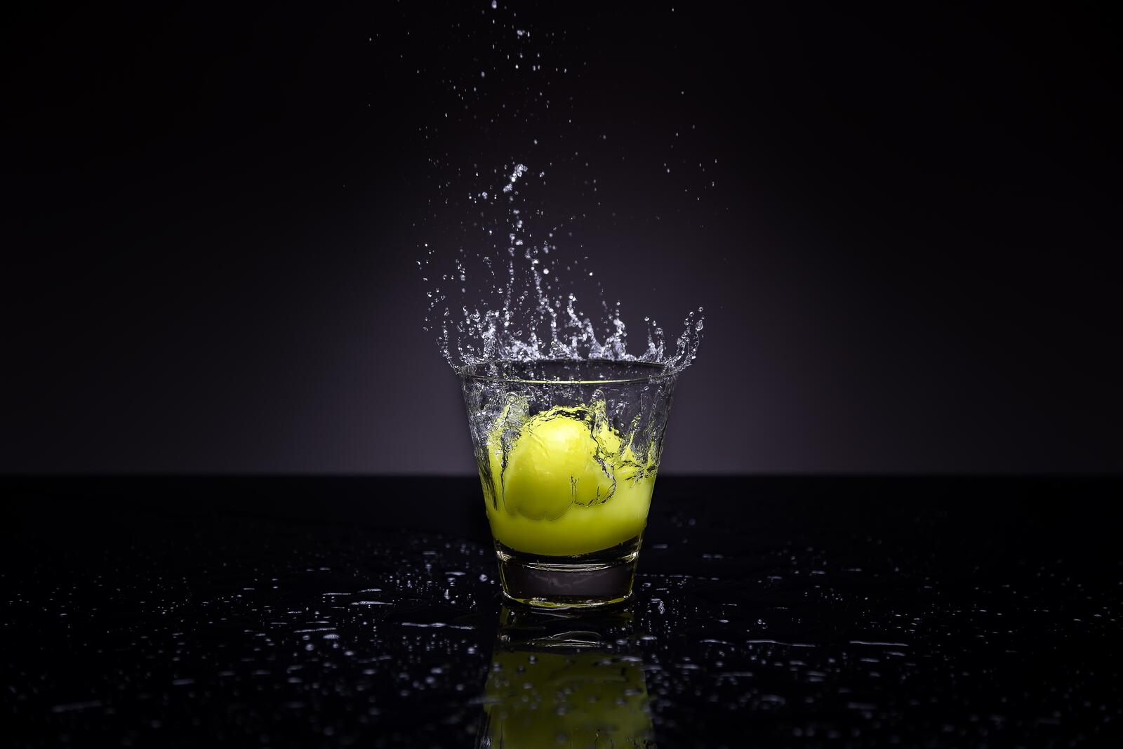 Бесплатное фото Половинка лимона падающая в стакан с водой