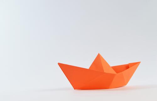 Бумажный кораблик оранжевого цвета