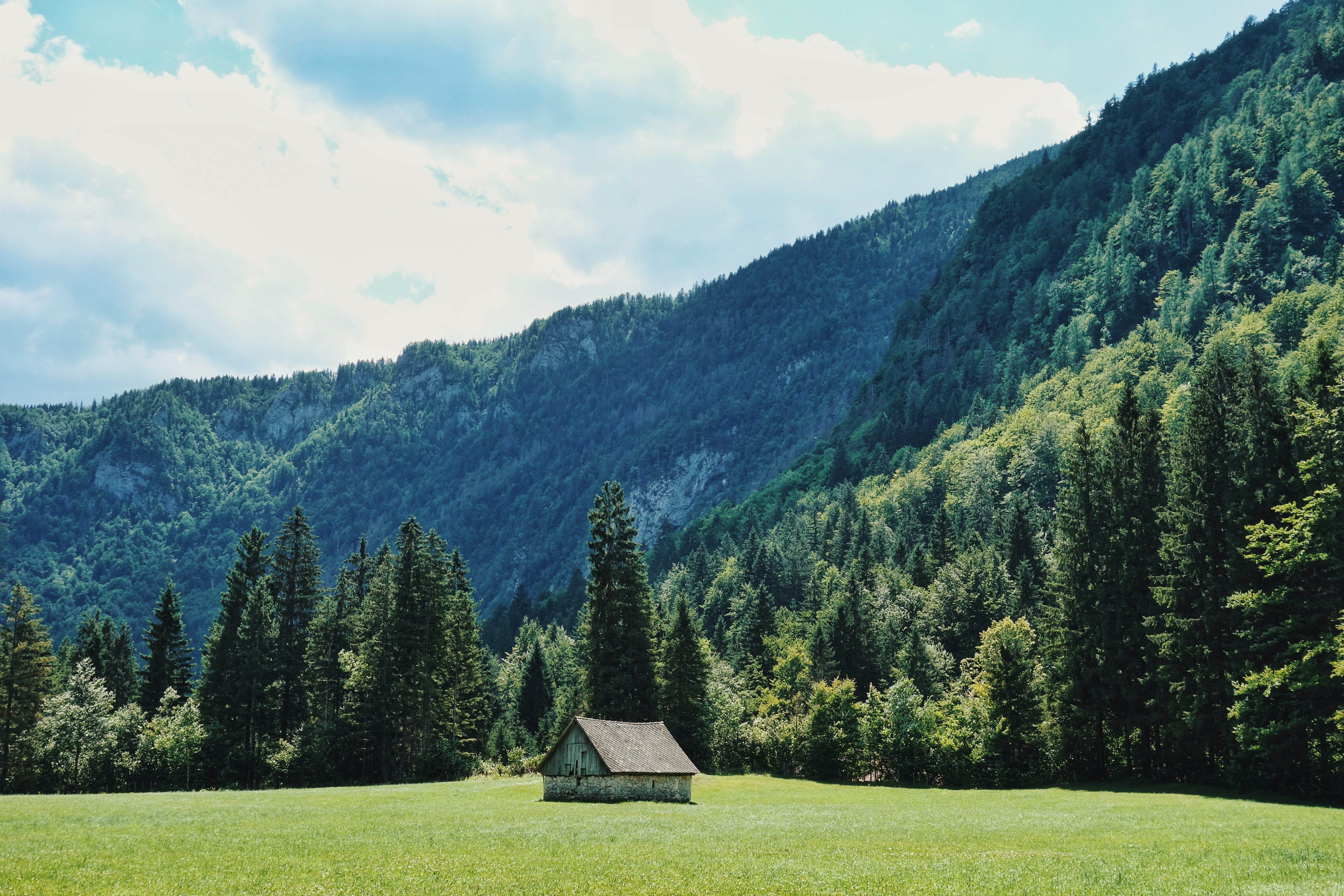 Бесплатное фото Одинокий домик в поле у подножья горы