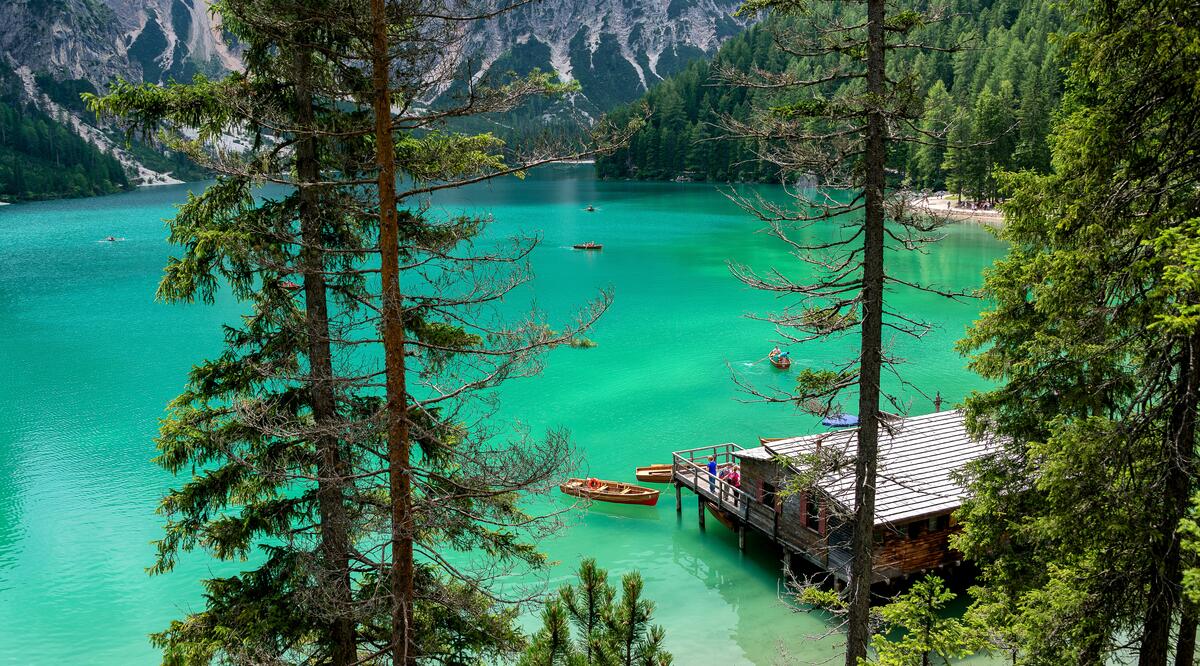 Деревянный дом с лодкой на красивом зеленом озере