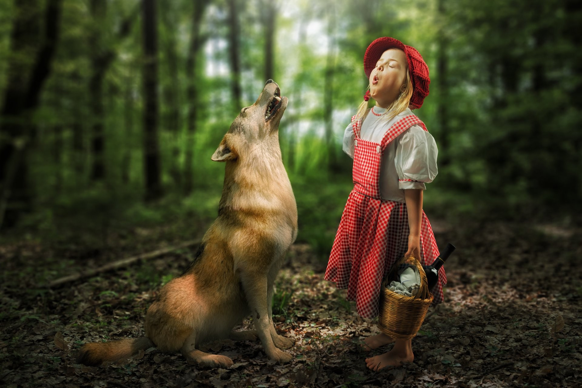 Бесплатное фото Маленькая девочка в красной шапочке с волком в лесу