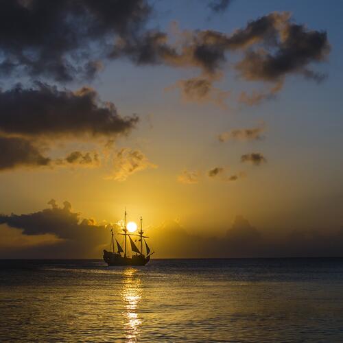 A large sailing ship at sunset