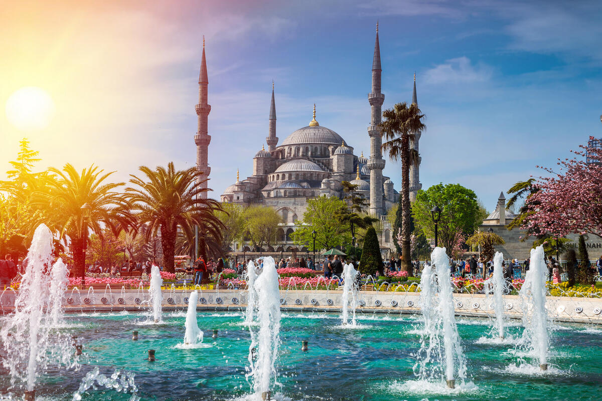 Красивый фонтан на фоне большой мечети в Турции