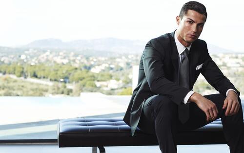 Cristiano Ronaldo in a black pinstripe suit.