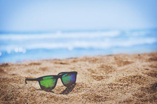Sunglasses lying on the sandy beach