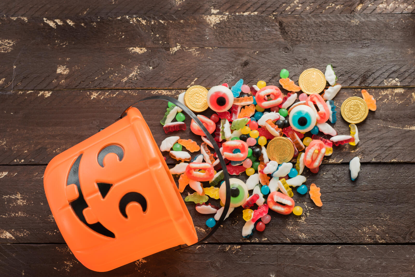 Free photo Delicious candy spilled out of a Halloween bucket.