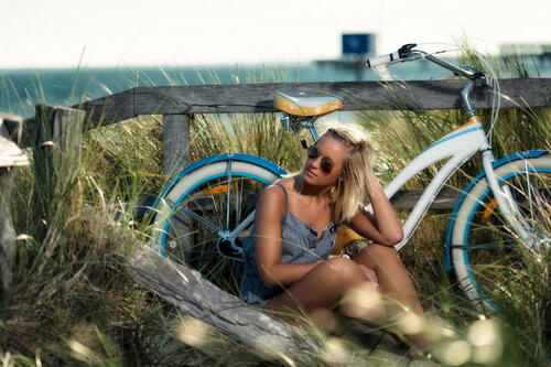 Девушка отдыхает на природе рядом с велосипедом