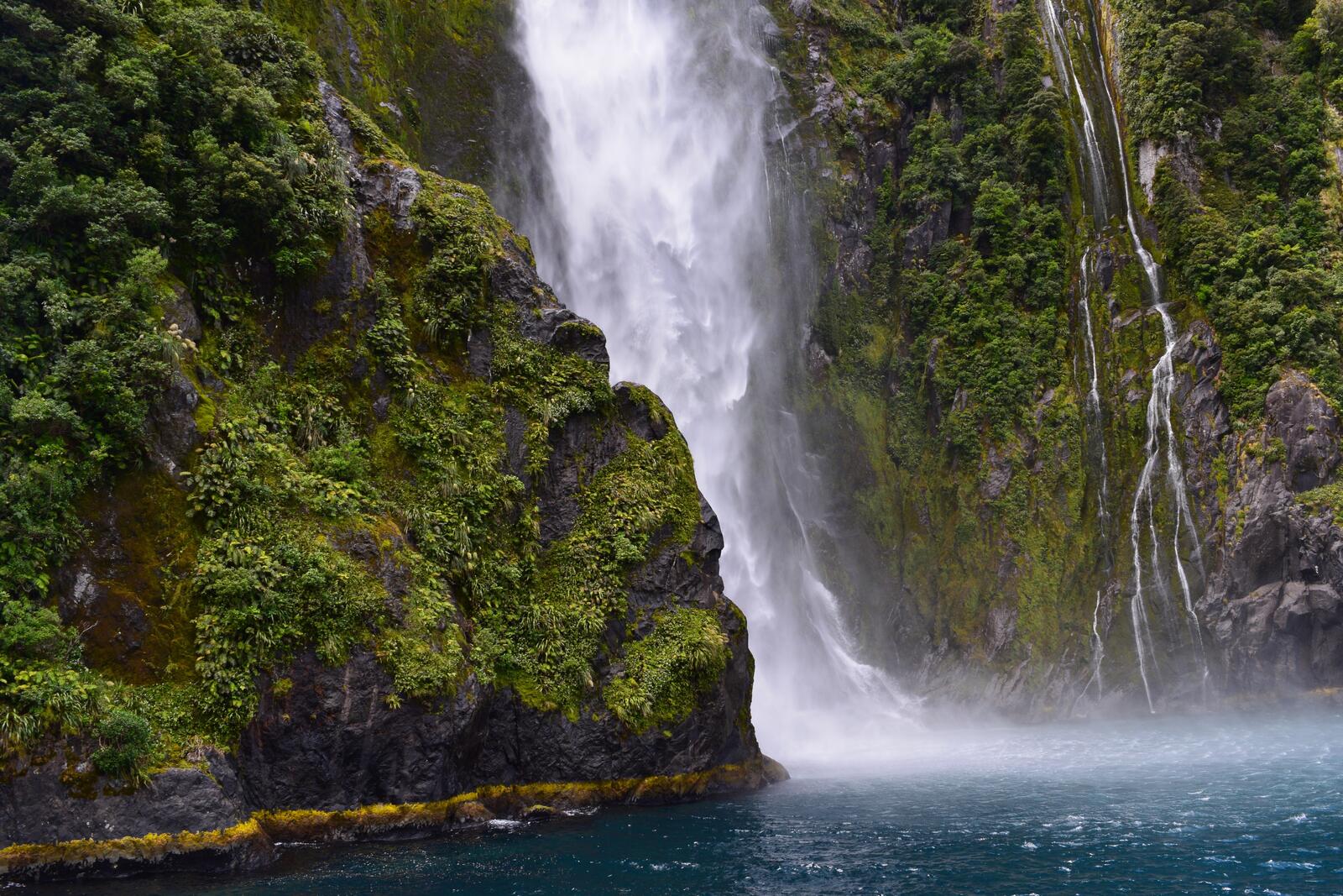 Бесплатное фото Водопад со скал покрытых зеленым мхом