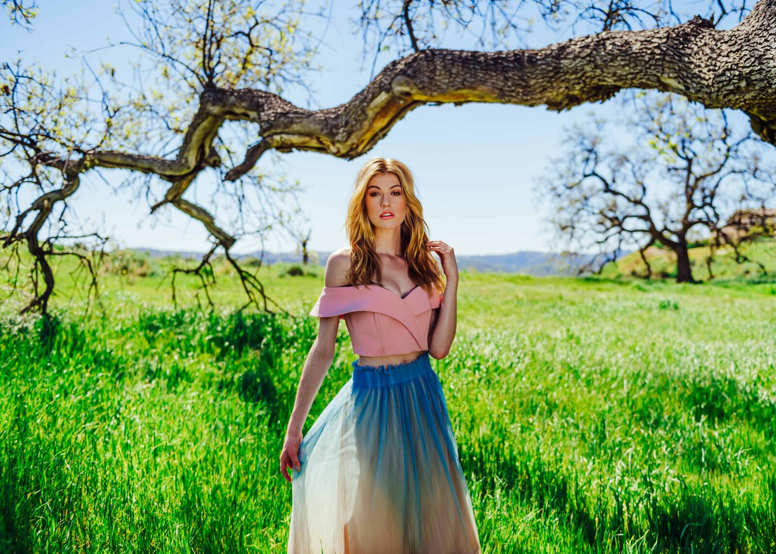 Free photo A girl in a light skirt against a green field