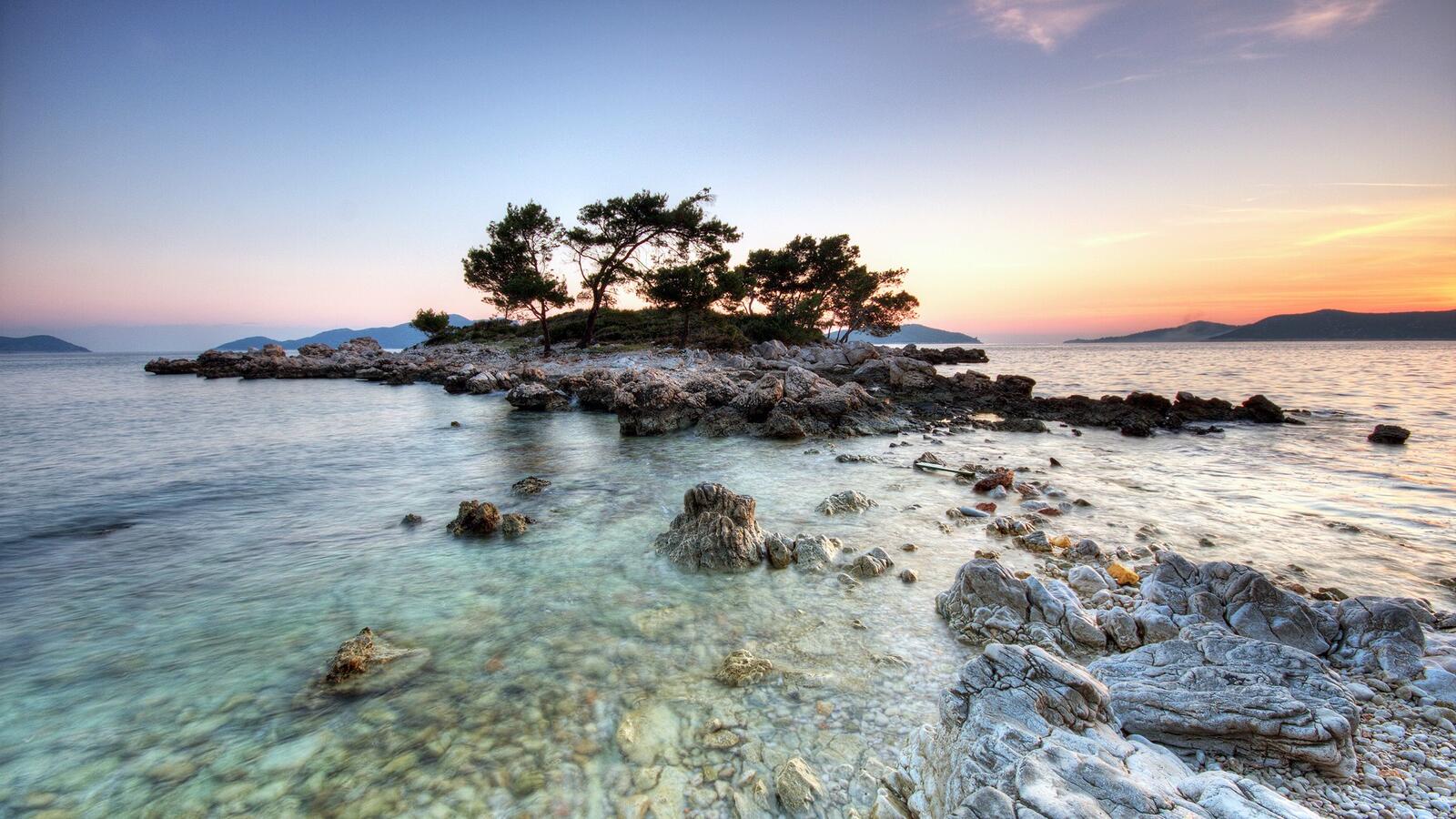 Бесплатное фото Скалистое дно у острова на закате