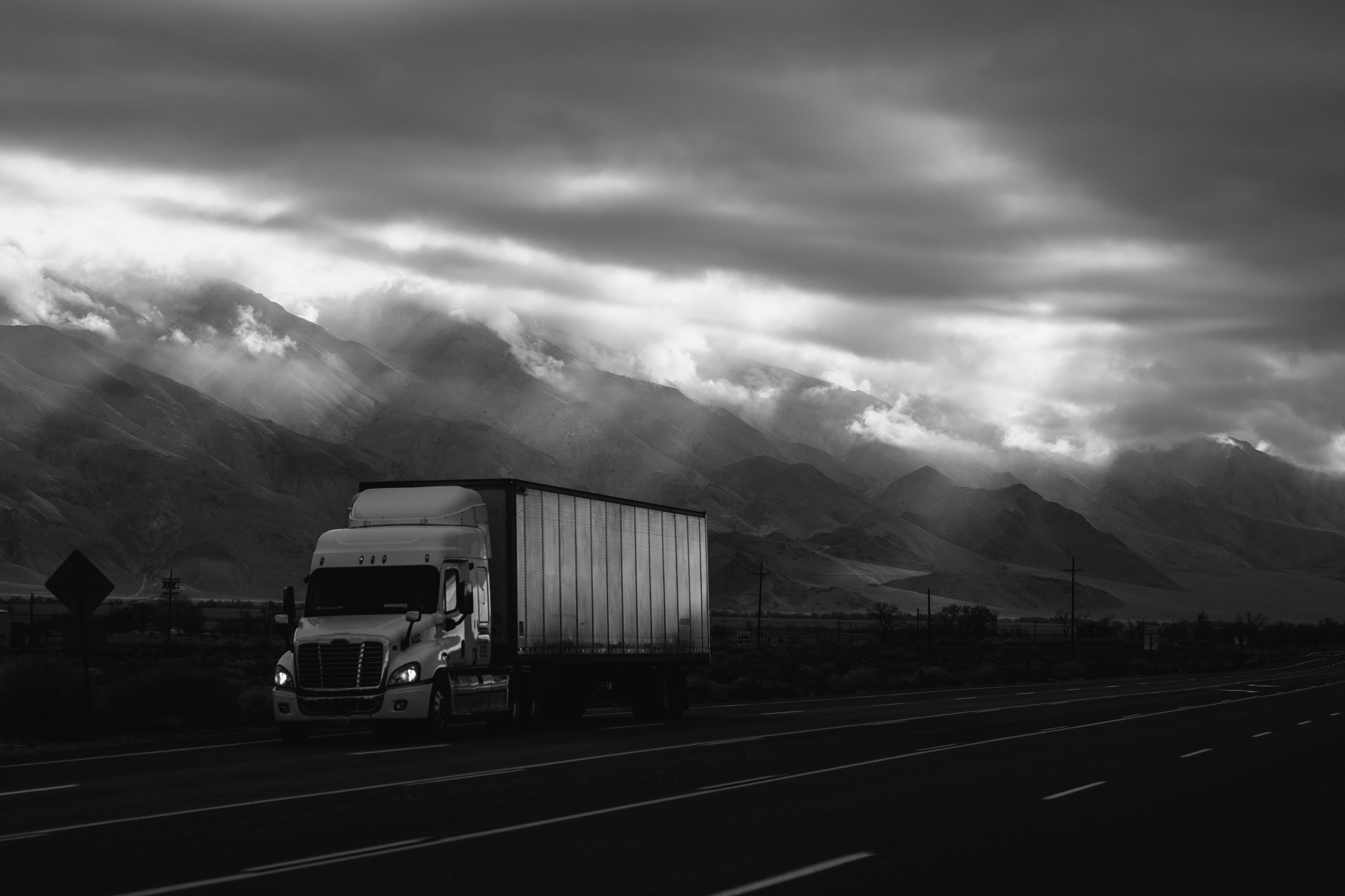 An American truck drives down the highway in a monochrome photo