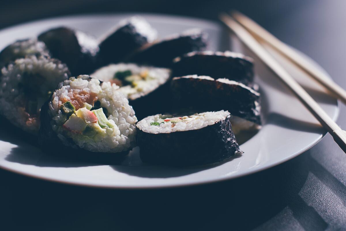 用筷子把寿司放在盘子里